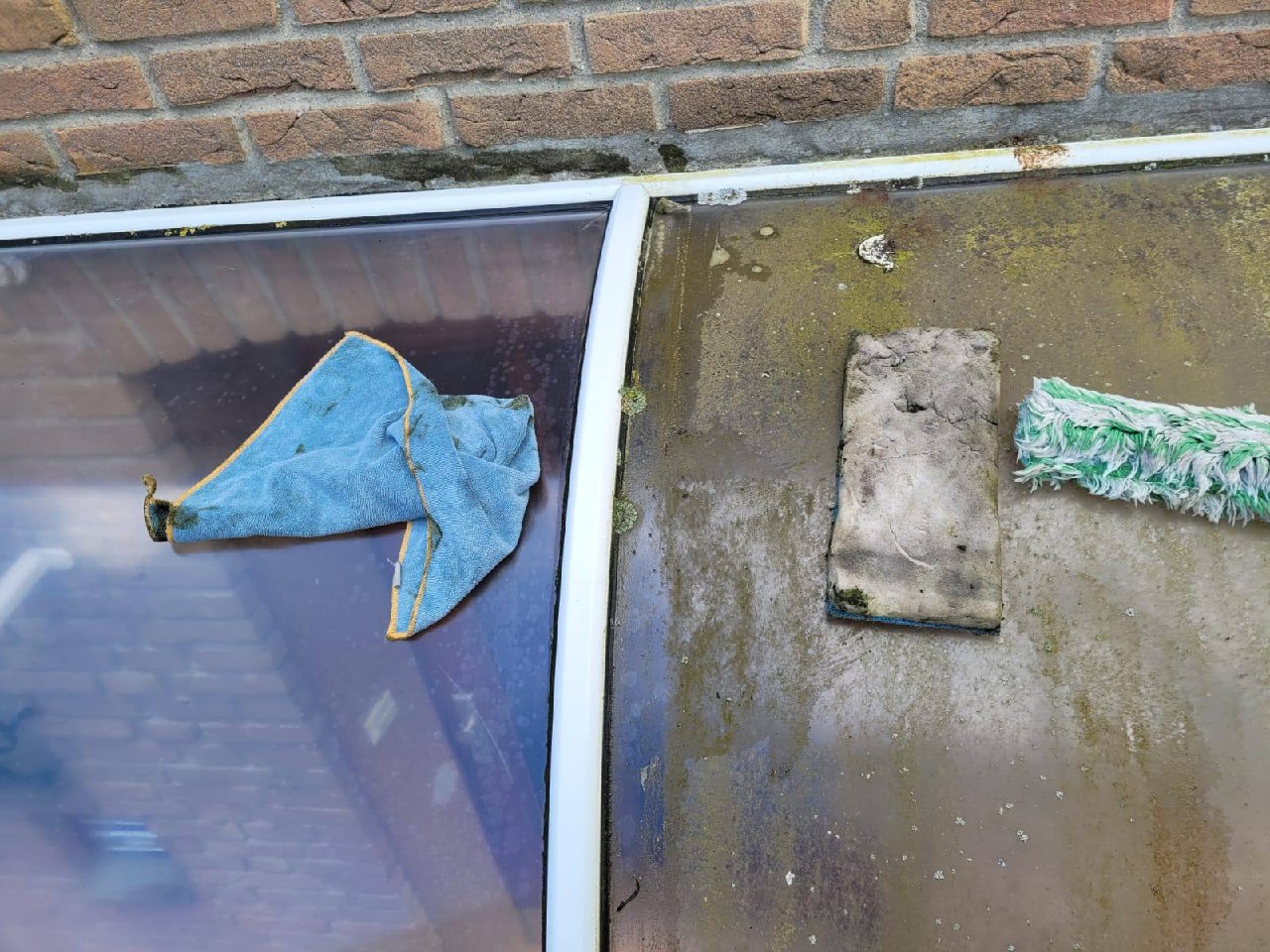 Glasreinigung an einem Glasdach mit Ledertuch und Abzieher